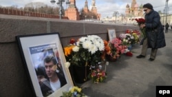 A woman lays flowers at the place where Boris Nemtsov was killed on February 26.