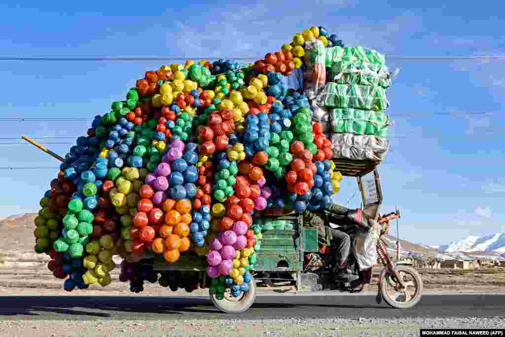 An Afghan vendor carries plastic containers on a three-wheeler rickshaw in Maidan Wardak Province. 