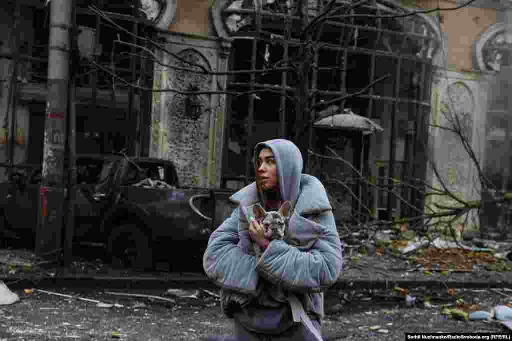 A woman holds her dog in the wake of a Russian strike in Kyiv on December 20, 2024.