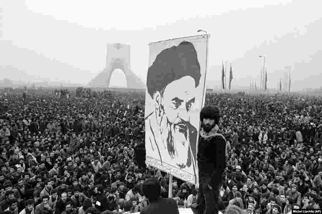 Demonstrators hold up a poster of exiled Islamic leader Ayatollah Ruhollah Khomeini as protests in Tehran grow larger. This anti-Shah demonstration on December 10, 1978 took place near the Shayah monument which was built to commemorate the monarch&#39;s rule and power.