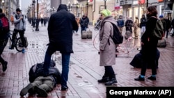 A plainclothes policeman holds down a journalist who was filming opposition activist Pavel Krysevich during his action on January 24 in support of Russian opposition leader Aleksei Navalny and against the mass arrests at a rally in Moscow.