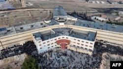 An aerial photo shows people gathering at the Saydnaya prison near Damascus on December 9, 2024.