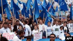 Azarbaijani opposition supporters hold posters and flags during a protest rally in Baku on April 22. 