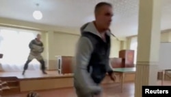 A gunman opens fire at a military draft office in Ust-Ilimsk in this screen grab obtained from social media.