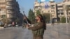 A Syrian opposition fighter shoots in the air in downtown Aleppo on November 30. 