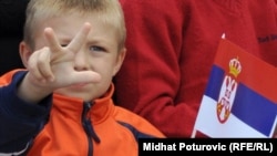 A child shows the traditional Serb three-finger salute in Pale, in Bosnia's Republika Srpska, on September 8. He's waving the Serbian flag.