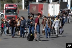 A group of Russians walk after crossing the border at Verkhny Lars between Georgia and Russia on September 27, 2022, the day after Russian President Vladimir Putin announced a partial mobilization.