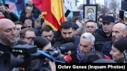 Calin Georgescu and dozens of his supporters gather outside a closed polling station in Bucharest on December 8.