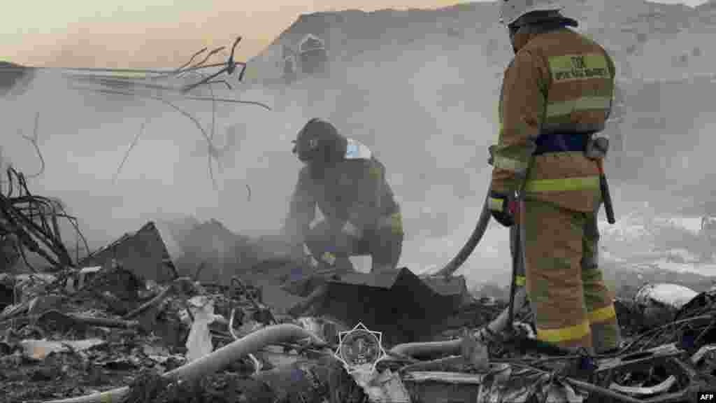 Kazakh emergency specialists work at the crash site of an Azerbaijani passenger jet that crashed in the western city of Aqtau on December 25, killing dozens.