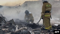 Kazakh emergency specialists work at the crash site of a passenger plane near Aqtau on December 25.