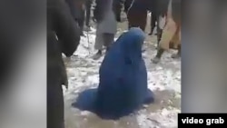 A screen grab from an amateur video of a mob beating an Afghan woman in Takhar Province because she allegedly had an extramarital affair. The woman survived the incident. 