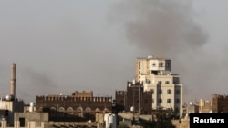 Smoke rises over the Yemeni capital, Sanaa, after the city's airport was hit by Israeli air strikes on December 26