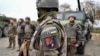 Ukrainian soldiers of the 155th Separate Mechanized Brigade stand next to military vehicles during a training exercise in France. 