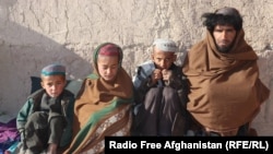 Naqibullah sits with his two sons and his nephew (far left) outside of his home on the outskirts of Tarin Kowt.