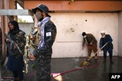 Taliban fighters stand guard outside a hospital in Kabul in November 2021 after an attack claimed by IS-K. At least 19 people were killed.