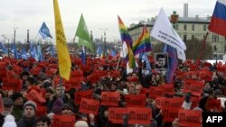 People hold portraits of late opposition leader Boris Nemtsov and placards reading "Who ordered?" during the memorial march in St. Petersburg in February 2017.