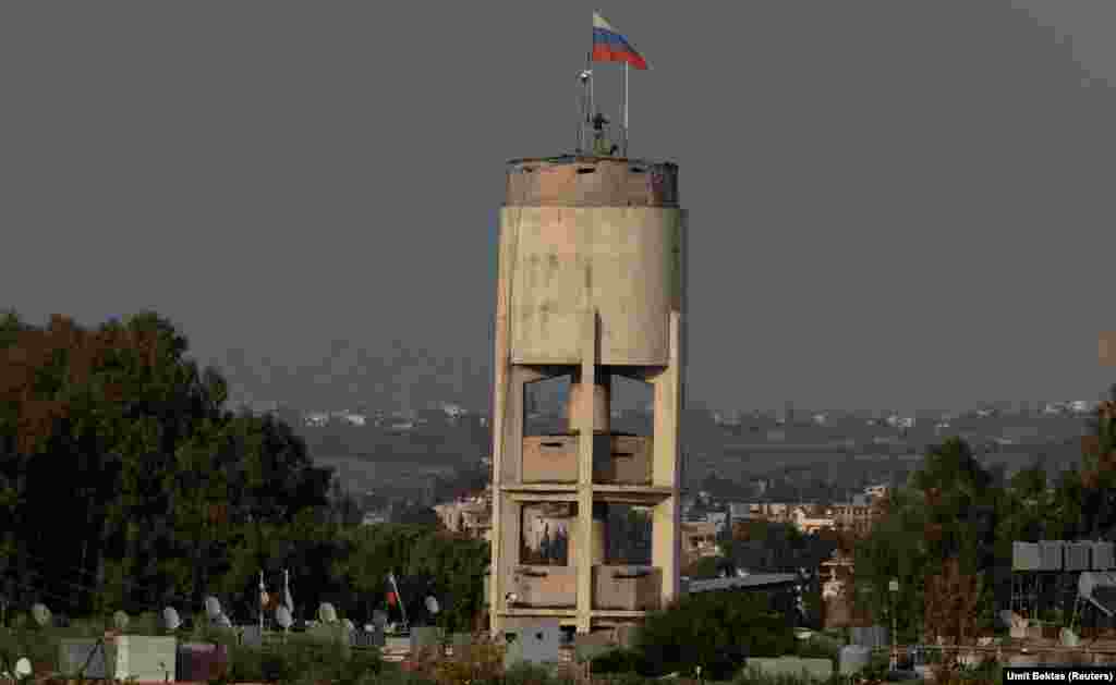 Russian servicemen install what appears to be a camera system atop a water tower inside the Hmeimim base.&nbsp; As well as this apparent CCTV system, which Bektas captured being built, he says there&#39;s also &quot;an eye-in-the-sky surveillance system, like a zeppelin on top of the air base for watching around.&quot;