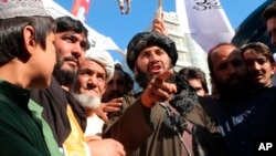 The dead body of a man accused of kidnapping hangs from a crane in the western Afghan city of Herat on September 25.