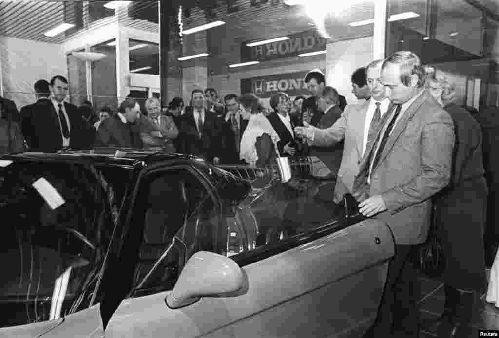 Putin (front right) looks at a Honda car during a ceremony in St. Petersburg on April 29, 1993.