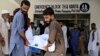 People move the body of a bus accident victim from a hospital in Kahuta, Punjab Province on August 25.