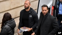 Andrew Tate (center) and his brother Tristan (right) are brought by police officers to the Court of Appeal in Bucharest on January 10.