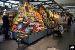 Traders prepare vegetables for customers at the Dorogomilovsky food market in Moscow in September. Prices of groceries have skyrocketed in Russia.