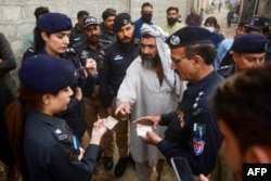 Pakistani police officers check the documents of Afghan refugees near Karachi. (file photo)