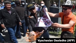 Kyrgyz men burn a placard during an anti-gay rally in Bishkek in April 2021.