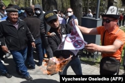 Kyrgyz men burn a placard during an antigay rally in Bishkek in April 2021.