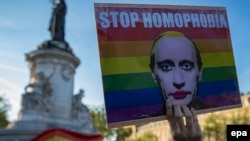 A demonstrator holds a placard depicting Russian President Vladimir Putin with the label "Stop Homophobia" to denounce the antigay campaign launched in the Russian region of Chechnya during a protest held in Paris on April 20.