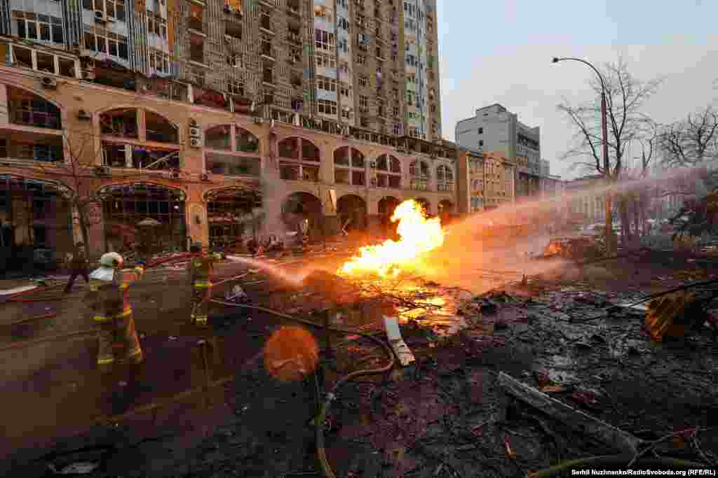 Firefighters work amid burning rubble. Ukrainian military authorities reported that Russia fired eight missiles at the capital.