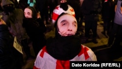 Protesters in Tbilisi wear masks in defiance of a new law banning face-coverings in Georgia.