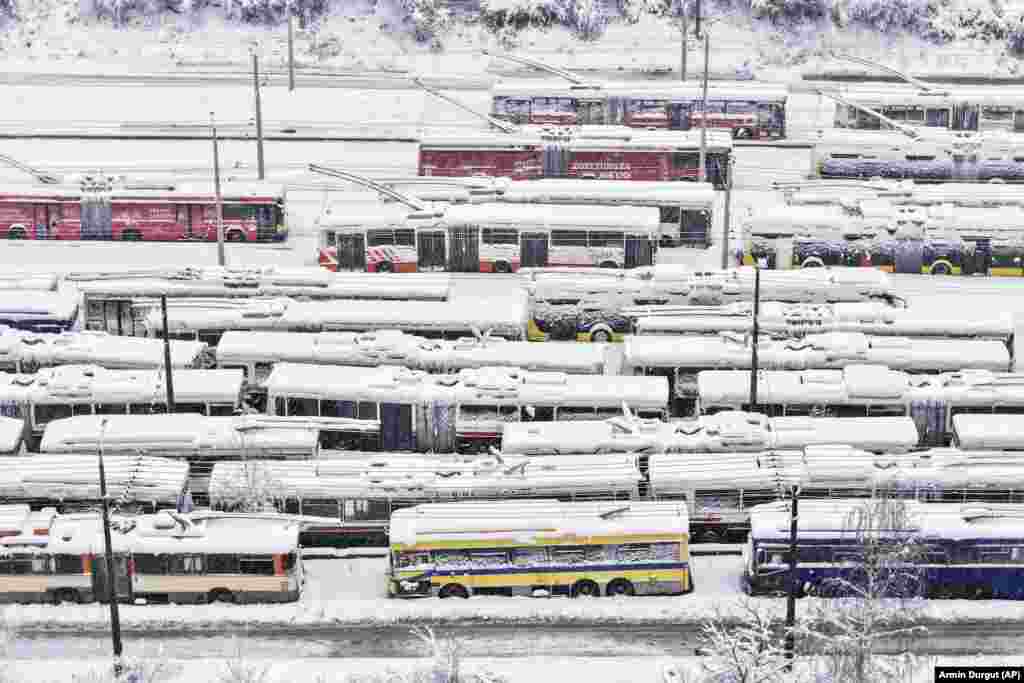  An aerial view of parked trolley buses during heavy snowfall in Sarajevo. &nbsp; 