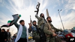 Syrian opposition fighters celebrate after the Syrian government collapsed in Damascus, December 8.