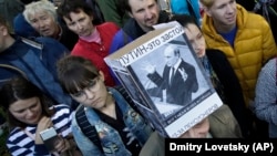 A protester wearing a hat depicting Russian President Vladimir Putin and reading "Putin Means Stagnation" during a rally against pension reform in St. Petersburg on September 16.