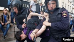 Riot police detain a man during an anticorruption protest on Tverskaya Street in Moscow. Protest organizer Aleksei Navalny has faced criticism for moving the demonstration to the Russian capital's central thoroughfare at short notice. 