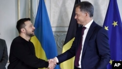 Ukrainian President Volodymyr Zelenskiy (left) and Belgian Prime Minister Alexander De Croo shake hands after signing a bilateral security agreement in Brussels on May 28.
