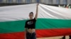 A protester holds a giant Bulgarian flag during September 2020 protests in front of the parliament building in Sofia.