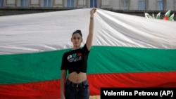 A protester holds a giant Bulgarian flag during September 2020 protests in front of the parliament building in Sofia.