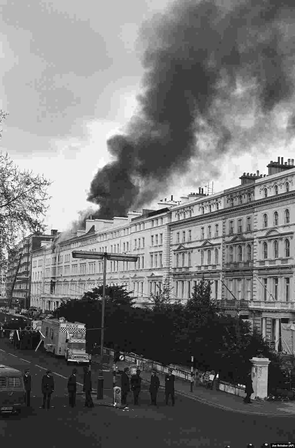 Black smoke pours from the roof of the embassy on May 5, after police and an SAS unit ended the six-day siege. Machine-gun fire was heard and an explosion followed.