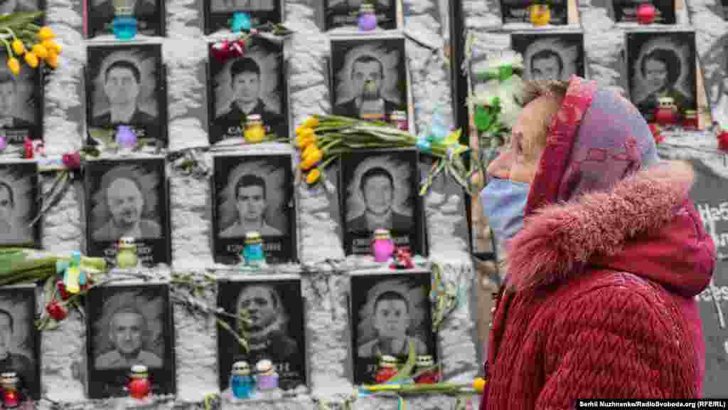 A woman is seen on February 18 in front of the &quot;Heavenly Hundred&quot; monument in Kyiv, honoring the 104 people killed during anti-government demonstrations in 2014. 