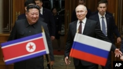 Russian President Vladimir Putin (right) and North Korean leader Kim Jong Un meet at Pyongyang Sunan International Airport outside Pyongyang, North Korea, on June 19.