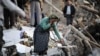 A woman walks among destroyed houses in the Iranian city of Varzaqan in Iran's northwestern province of East Azerbaijan on August 12.