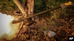 A soldier of Ukraine's 24th Mechanized Brigade fires an anti-tank grenade launcher toward a Russian position at Chasiv Yar.