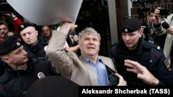 Police officers detain Yabloko's Sergei Mitrokhin during a protest against a housing resettlement program in Moscow in June 2017.