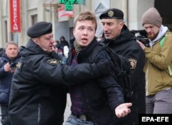 Police officers detain Raman Pratasevich as he attempts to cover a rally in Minsk in March 2017.