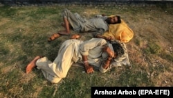 Pakistani drug users sleep after consuming drugs on a roadside in Peshawar, Pakistan. 