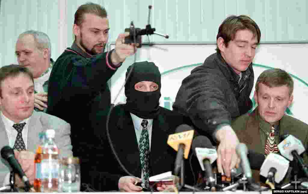 Journalists prepare microphones for a press conference by officers of the Russian Federal Security Service (FSB) at the Interfax news agency in Moscow on November 17, 1998. Former agent Mikhail Trepashkin (seated left), a colleague wearing a mask to protect his identity (center), and Litvinenko (right) accused their FSB commanding officers of ordering kidnappings and assassinations, including an attempt to kill billionaire businessman and power broker Boris Berezovsky.&nbsp;