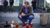 A man in Novi Sad lights candles to pay his respects to the people who died when a part of a roof collapsed in a railway station in the Serbian city on November 1. 