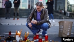 A man in Novi Sad lights candles to pay his respects to the people who died when a part of a roof collapsed in a railway station in the Serbian city on November 1. 